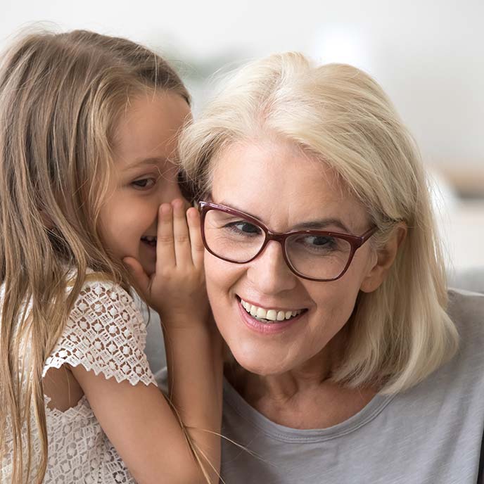 Kind sagt Frau etwas ins Ohr - Tinnitus-Wissen